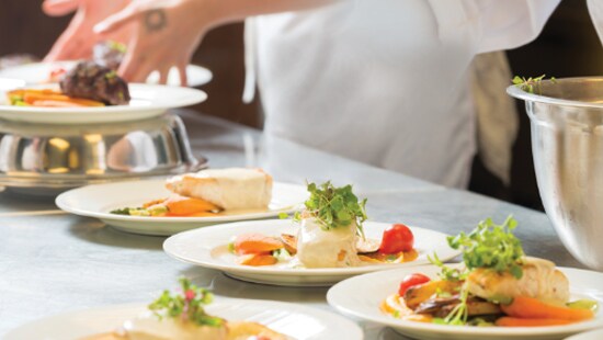 Restaurant kitchen staff plating safe food for dinners.