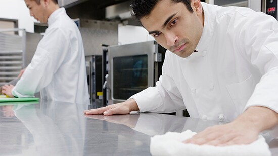 Chef wiping counter in a commercial kitchen