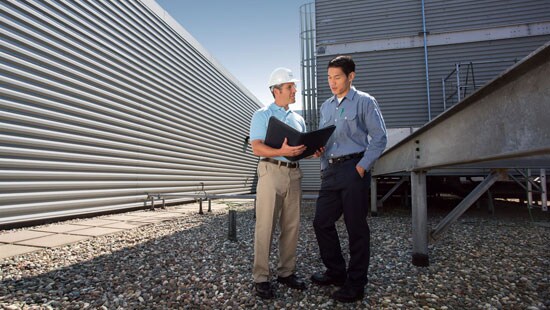 Two men viewing a clipboard