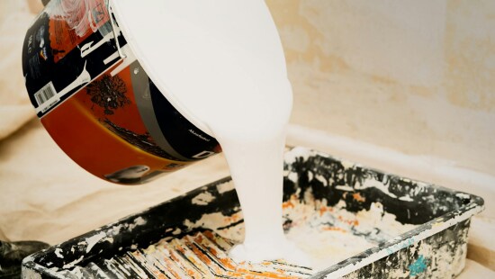 Paint pigments being poured into drip tray.