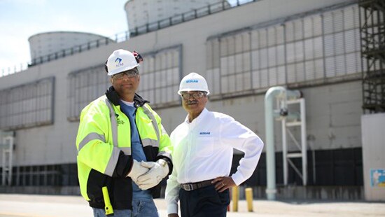 Sustainability practices image featuring Ecolab representative and customers at a facility